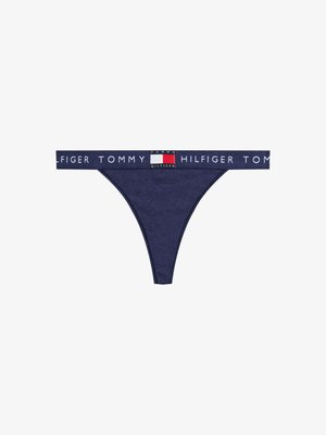 String bleu marine avec une ceinture élastique de marque affichant "TOMMY HILFIGER" en blanc, avec un accent de logo coloré. Texture de tissu douce.