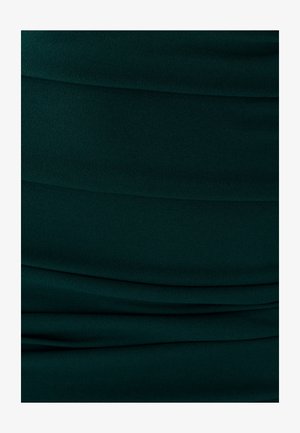 Tissu vert foncé texturé avec des plis doux et drapés, créant une apparence ondulée. Surface lisse, léger avec un léger éclat.