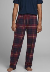 Pantalones de pijama de cuadros en rojo oscuro y azul marino con detalles amarillos, que presentan un corte holgado y cintura elástica. Tejido suave con una textura lisa.