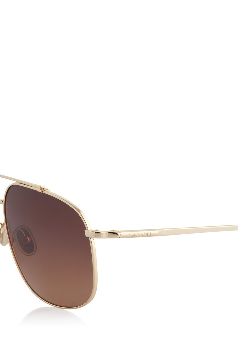 Lunettes de soleil aviateur en métal doré avec verres dégradés marron, présentant une fine monture et des accents de temple signés. Design léger.