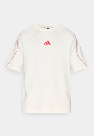 Crèmekleurig t-shirt met korte mouwen, rode accenten langs de naden en een rode Adidas-logo op de borst. Gemaakt van zachte stof.