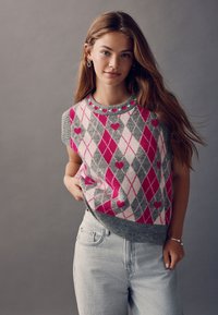 Sleeveless sweater featuring a gray, pink, and white argyle pattern with heart accents; ribbed neckline and hem, made from a soft material.