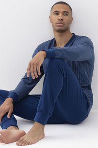 Navyblauw pyjama set in een gestreept ontwerp met lange mouwen en elastische manchetten. Zachte stof, met een V-hals en aansluitende broek.