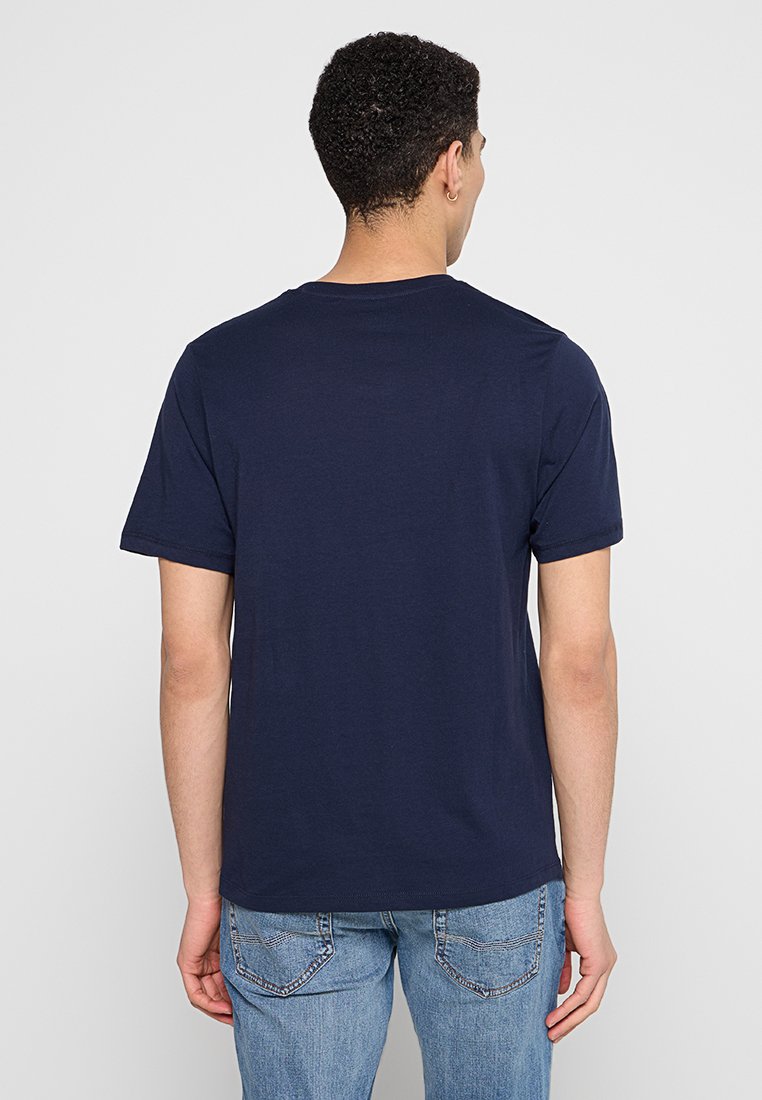 Camiseta de algodón de manga corta en azul marino, con un cuello redondo y un corte relajado. Presenta una parte trasera lisa y una textura suave.