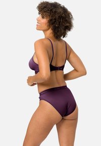 Purple lingerie set featuring a bralette with thin straps and matching briefs. Smooth fabric with a subtle sheen and elastic waistband.