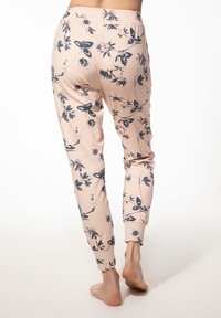 Lichtroze joggerbroeken met een bloemenpatroon in donkerblauw. Gemaakt van zachte stof, met elastische manchetten en een comfortabele tailleband.