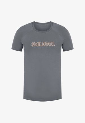 Camiseta de manga corta gris con un escote redondeado. Presenta un logo impreso "SMILODOX" en color naranja claro en el pecho. Textura de tela suave.