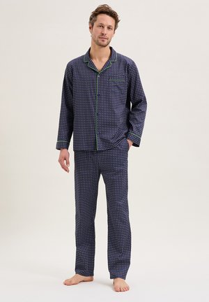 Ensemble de pyjama bleu marine avec des pois blancs, passepoil vert contrastant, manches longues, fermeture à boutons et pantalon à jambes droites. Matière en coton doux.