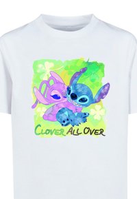 Hvid t-shirt med et farverigt grafik af to tegneseriefigurer i nuancer af lilla og blå, med en grøn baggrund og teksten "CLOVER ALL OVER."