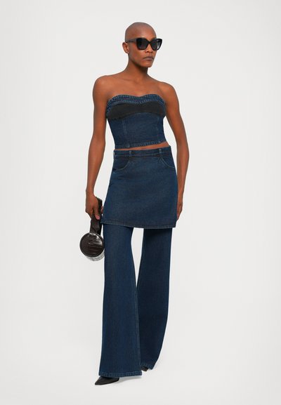Top strapless denim dengan aksen hitam, dipadukan dengan rok denim dan celana flare. Dilengkapi dengan tas bulat hitam yang bercorak.