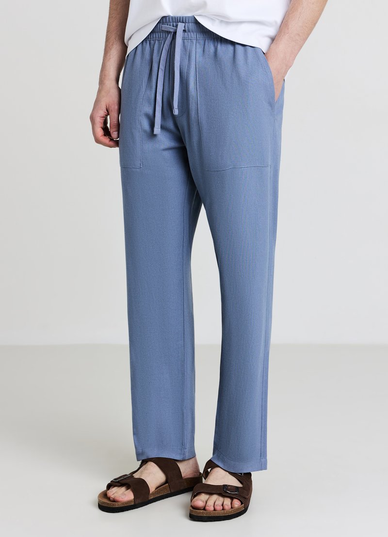 Hellblaue, locker sitzende Hose aus weichem Stoff mit elastischem Bund und Kordelzug, Seitentaschen und geradem Bein.