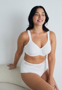White bra with wide straps and smooth finish, paired with high-waisted white panties featuring a sheer panel and cross design at the waist.