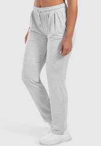 Graue Jogginghose aus weichem Stoff, mit einem elastischen Bund und Kordelzug, seitlichen Taschen und einem lockeren Schnitt.