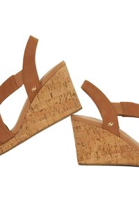 Sandales à talon en liège couleur châtaigne, avec un design à double lanière, une tige en cuir lisse et un accent de logo subtil sur le côté.