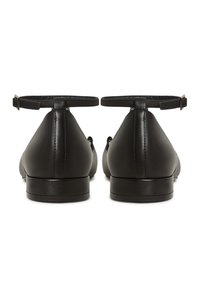 Schwarze Leder-Ballerinas mit einem Knöchelriemen, spitz zulaufender Zehenpartie und niedrigem Absatz. Glatte Oberfläche mit minimalistischem Design und gestickten Details.