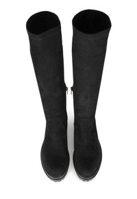 Botas altas de ante negro con una textura suave, puntera redondeada y suelas de goma negra. Cuenta con cremalleras en los lados interiores.