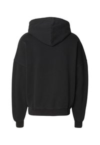 Melns kapučveida džemperis, pārlieku liels izmērs, mīksts kokvilnas maisījums, ribots aproces un apakšpuse. Skats no muguras izceļ gludo tekstūru un formu.