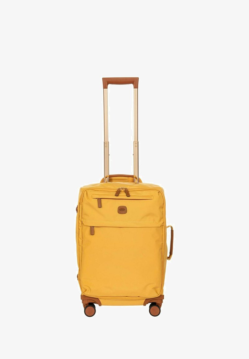 Valise compacte jaune à roulettes avec poignée télescopique, poches avant zippées, poignée latérale et quatre roues pivotantes.