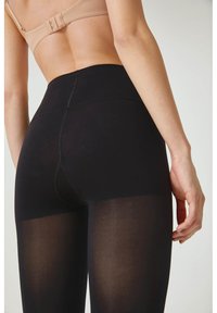 Schwarze Leggings aus einem glatten, dehnbaren Material. Hoch geschnittenes Design mit einer semi-transparenten Textur, Nähte, die hinten herunterlaufen, für einen figurbetonten Look.