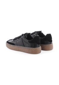 Ein Paar schwarze Low-Top-Sneaker mit strukturierten, tanfarbenen Gummisohlen, Wildleder-Fersenklappen und schwarzen Schnürsenkeln, von hinten und seitlich betrachtet.