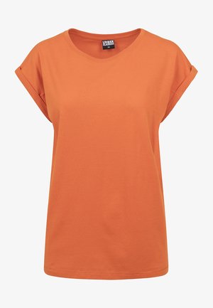 Camiseta de algodón naranja con un corte relajado, cuello redondo y mangas cortas enrolladas. Diseño simple sin patrones o acentos visibles.