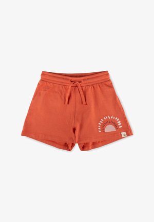 Pantaloncini di cotone color ruggine con vita regolabile con coulisse e un motivo a raggi solari sulla gamba inferiore destra su sfondo bianco.