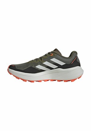 Des chaussures de course avec un dessus en maille vert olive, des rayures blanches, des accents noirs et une épaisse semelle blanche avec des crampons orange.
