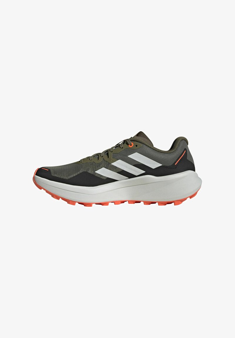 Zapatillas de correr con una parte superior de malla verde oliva, rayas blancas, acentos negros y una suela gruesa blanca con tacos de tracción naranjas.