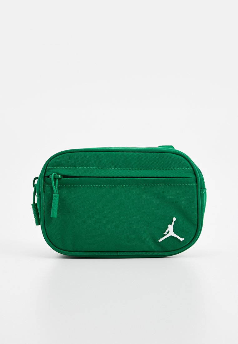 Zielona nylonowa torba w kształcie prostokąta, z przednią kieszenią na zamek błyskawiczny oraz białym logo Jumpman w prawym dolnym rogu.