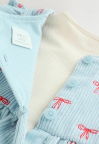 Ljusblå kordfloretklänning för baby med broderade röda rosetter, med en vit ribbad halsringning och blå knappar för stängning. Märkesskylt ingår.