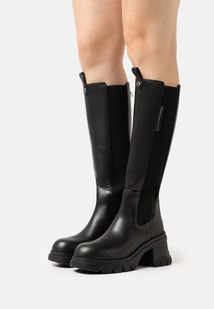 Zwarte kniehoge laarzen met een glad leren afwerking, elastische zijpanelen, opvallende blokhakken en getextureerde rubberen zolen voor grip.