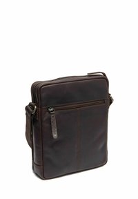 Borsa a tracolla in pelle marrone con forma rettangolare, zip superiore e tasca frontale. Presenta una texture con dettagli di cucitura visibili.