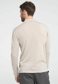 Lichtbeige poloshirt met lange mouwen en een subtiele textuur, van achteren weergegeven, met een rechte zoom.