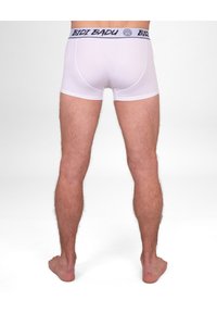 Boxer shorts bianchi con un elastico blu navy che presenta il testo "BIDI BADU". Texture liscia, design aderente e taglio a vita media.