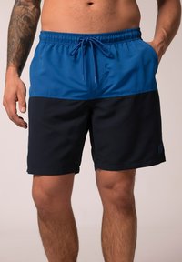 Costumi da bagno blu e blu navy con vita elastica, chiusura con cordino e tasche laterali. Tessuto liscio, lunghezza al ginocchio con dettagli del logo.