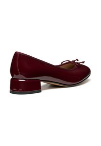 Scarpa bassa in pelle verniciata bordeaux con punta arrotondata, fiocco decorativo e tacco medio, caratterizzata da una finitura liscia e lucida.