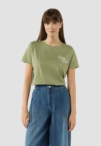 Olijf groene katoenen t-shirt met een ronde hals en korte mouwen, met witte tekst op de linkerkant van de borst. Losse pasvorm.