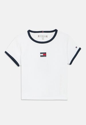 Maglietta bianca a manica corta per bambino con colletto e bordi delle maniche blu navy, con una toppa centrale con il logo Tommy Hilfiger e una piccola bandiera sulla manica.