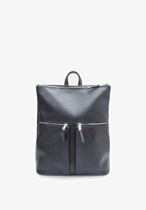 Must have nahk seljakott, millel on kaks lukuga esikotti, tekstureeritud pind ja ülemine käepide. Sujuvad lukud ja minimalistlik disain.