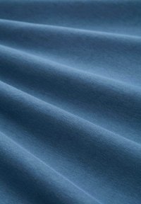 Baumwollstoff in einem weichen, mittleren Blauton, mit subtiler Textur, sanften Falten und einer einheitlichen Oberfläche. Leicht und gut fallend.