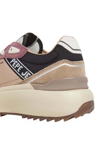 Baskets avec un dessus synthétique beige et noir, des accents en daim, un col rembourré et une marque blanche. Semelle intermédiaire épaisse blanche avec une semelle extérieure texturée marron.