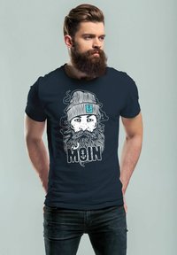 Marineblaues T-Shirt mit einer detaillierten weißen Grafik eines bärtigen Mannes im gestreiften Beanie, mit dem Wort "MOIN" in fetter Schrift.