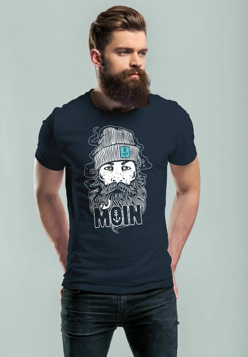 Marineblaues T-Shirt mit einer detaillierten weißen Grafik eines bärtigen Mannes im gestreiften Beanie, mit dem Wort "MOIN" in fetter Schrift.