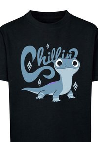 Melna kokvilnas T-krekls ar karikatūru dinozauru zila krāsā ar lielām acīm un tekstu "Chillin'" gaiši zilos toņos ar savīti dizainu.