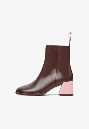 Stivale alla caviglia in pelle marrone con una forma affusolata e un tacco a blocco rosa a contrasto. Texture liscia e design minimalista con una maniglia sul retro.