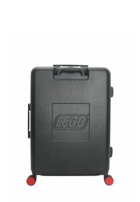 Black hardshell suitcase with a prominent LEGO logo, two red wheels, a top handle, and smooth, textured surface.