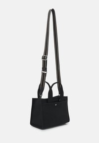 Sac à main en tissu rectangulaire noir avec des anses courtes et une longue bandoulière réglable comportant des rayures beiges et une quincaillerie argentée.