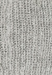 Tessuto grigio chiaro lavorato a maglia con una superficie morbida e testurizzata; presenta un motivo a coste con fibre visibili e sottili variazioni di tonalità.