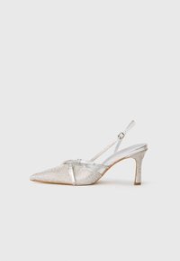 Norādītā pirksta sudraba slingback zābaks ar metāliski spīguļojošu virsmu, grezns ar spīguļojošiem akcentiem un strukturētu papēdi. Platas siksniņas detaļas.