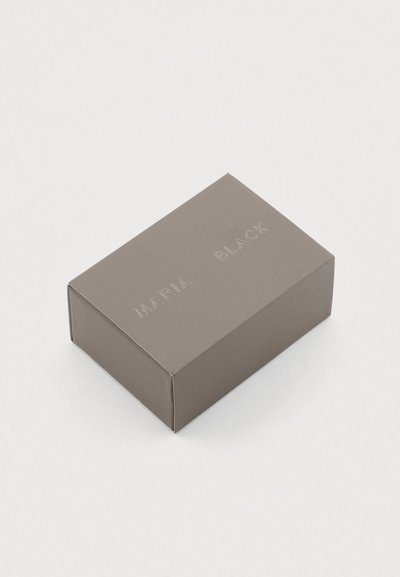 Γκρι ορθογώνιο κουτί με ανάγλυφο κείμενο "MARIA BLACK" στην κορυφή. Λείο ματ φινίρισμα, μινιμαλιστικός σχεδιασμός, καθαρές άκρες.